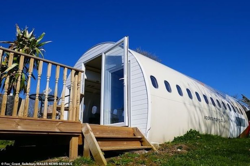 The 50-year-old said: 'I took my mum shopping to Cotswold airport, as you do. We were shopping for a plane to recycle and I came across the Jetstar, which is the 1970s private jet.' (Pictured: two wooden stairs leading up to a long and rounded white spaceship)