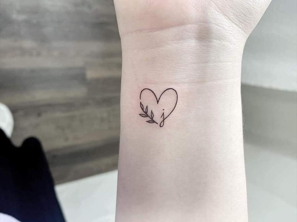 78 Tatuajes Pequenos Esteticos corazon con letra jota pequena y ramita en muneca