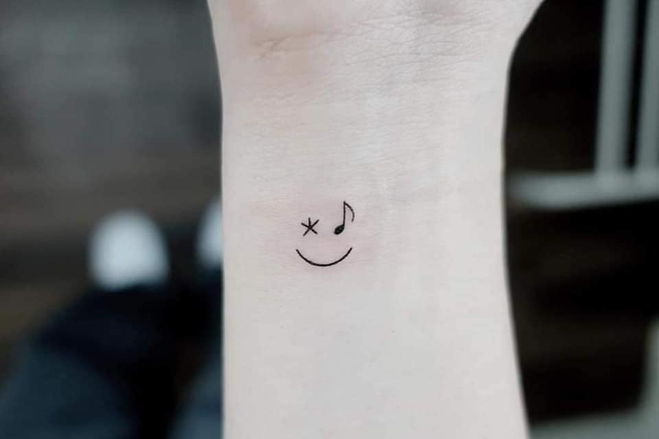 89 Tatuajes Pequenos Esteticos en muneca media sonrisa con estrella y clave de sol