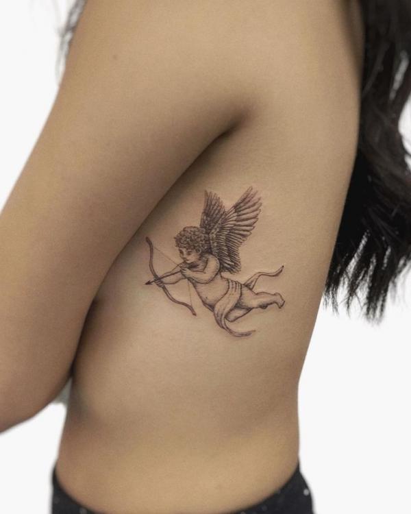 Small cupid tattoo on side