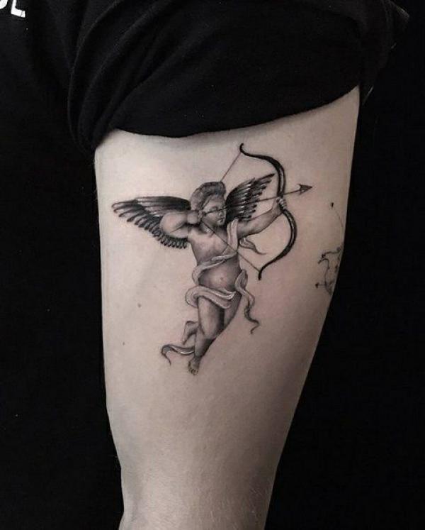 Small cupid tattoo on upper arm